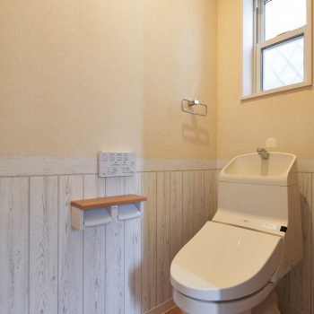 ホワイトの木目とテラコッタ調のタイルを使用して、南欧風のイメージのトイレ